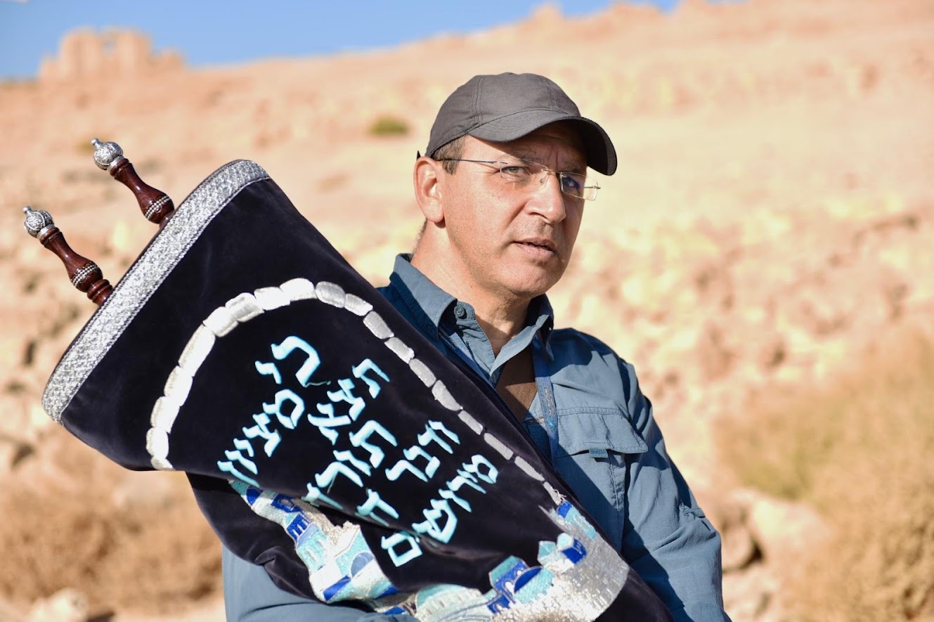 Man holding a Torah in the desert