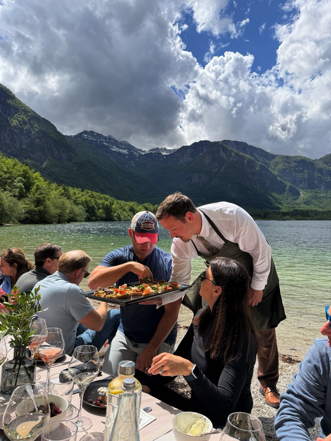 Waiter handing out food by the shore during a destination celebration